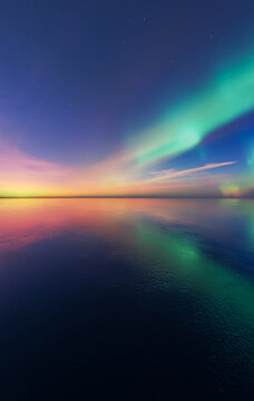 Northern Lights Aurora Over Calm Sea at Sunset With Colorful Sky and Reflection &mdash; 3D Rendering