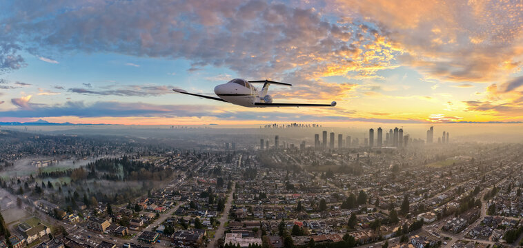 Private Jet Flying Over Misty Suburban City at Sunrise With Distant Skyline &mdash; 3D Rendering