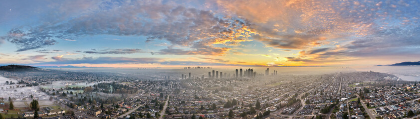 Obraz premium Aerial Panoramic Sunrise Over Burnaby Vancouver Skyline With Morning Fog and Cityscape