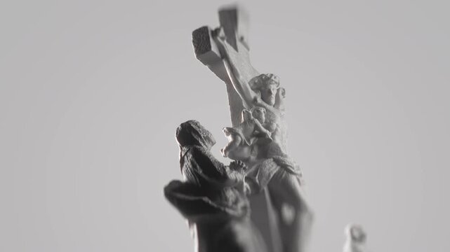 Artistic Close Up Of Grieving Statue Face Looking Up In Sorrow Below Depiction Of Jesus Christ On Cross Against Grey Background. Good Friday Symbol. Christian Concept Lent And Good Friday Sacrifice.