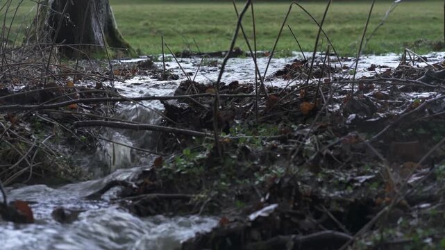 Flooded river with strong current and overflow, high water level in natural landscape &ndash; extreme weather footage