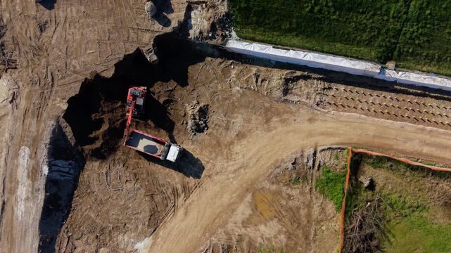 Construction Site: High-angle shot of an excavator, diligently at work on a construction site, highlighting industry, machinery, and the process of development and progress.