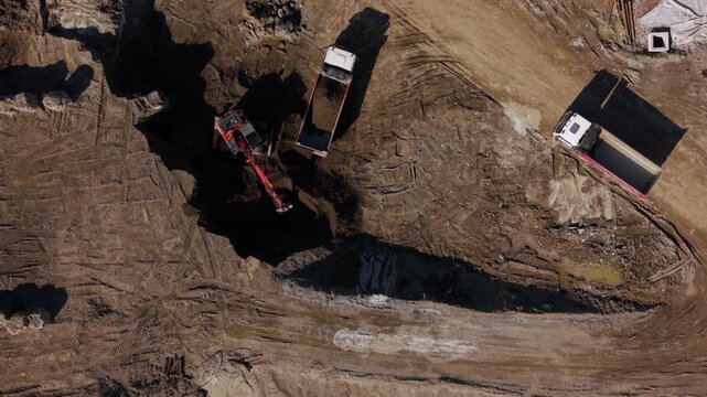 aerial perspective offers a stark view of a construction site with heavy machinery, illustrating the scale and activity of a modern development.