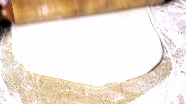 The cook rolls out the dough. Video