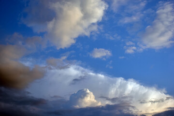 Obraz premium Dramatic Blue Sky Filled With Fluffy Clouds and Sunlit Storm Clouds Over Horizon