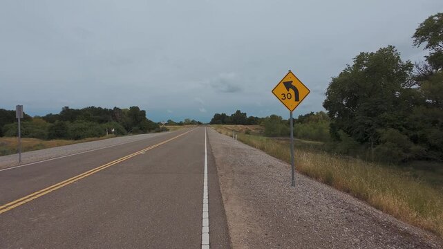 Rural road with a curve warning and 30 mph speed sign