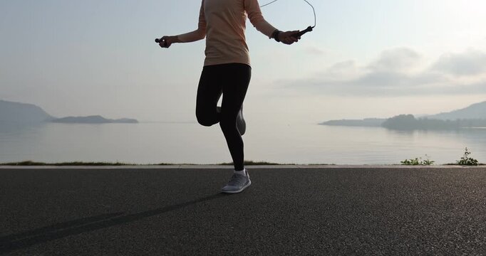 Fitness woman rope skipping  at seaside