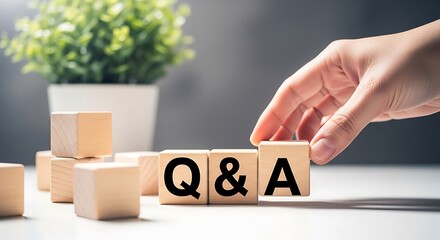 Naklejka premium Person's hand arranging wooden blocks with q&a text, representing questions and answers, education, and information exchange, q and a