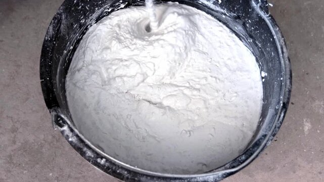 Mixing putty with a mixer.