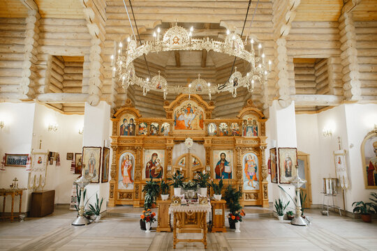 Orthodox church interior featuring ornate iconostasis and chandelier