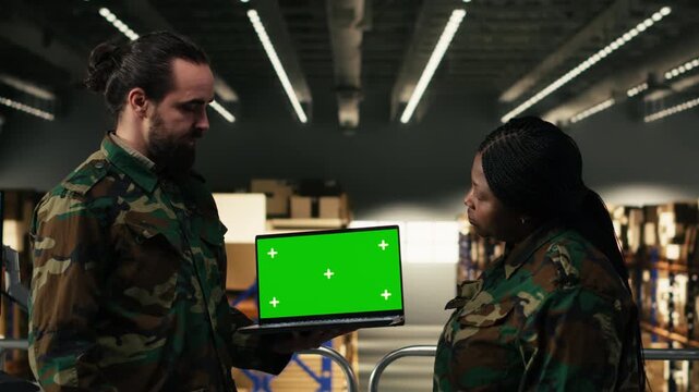 Chroma key on laptop near army soldiers team operating in warehouse for defense operations, ensuring supply chain coordination for national security. Operational management and logistics.