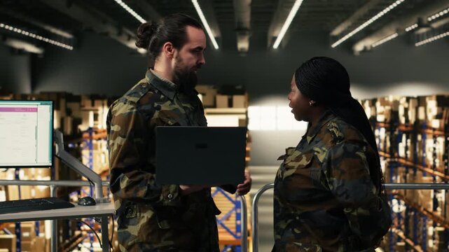 Diverse military officers working in storage warehouse and managing cargo for defense, inventory supervision. Personnel ensuring command and control systems on platform facility.
