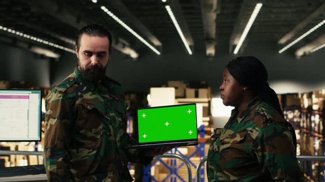 Green screen on laptop near armed forces team operating in warehouse for defense, ensuring supply chain management for national security operations. Command and control logistics.