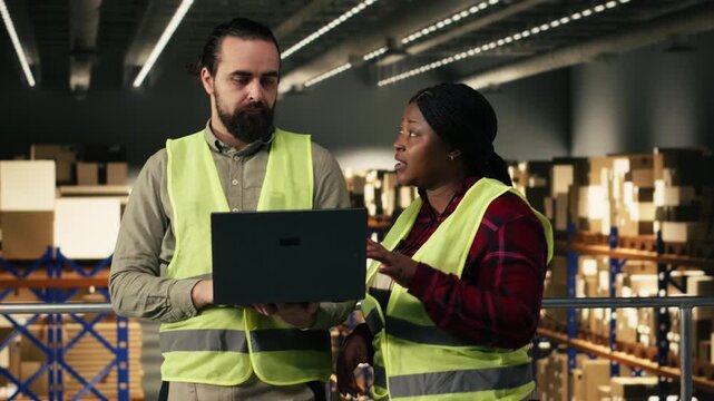 Diverse warehouse staff using tracking info to optimize shipping operations and order fulfillment in distribution center. Employee tracking packages and managing stock, logistics planning.