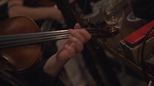Fiddle violin musician playing notes in Irish pub traditional  music session