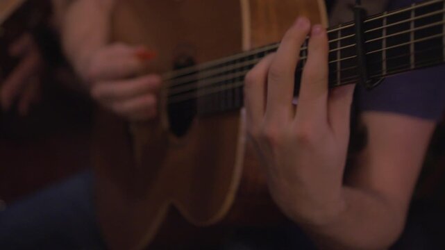 Guitarist musician playing acoustic guitar fast tempo strumming hands close up