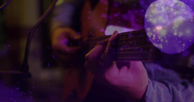 Guitarist playing guitar for music recording, camera widening while purple bokeh overlaying frets