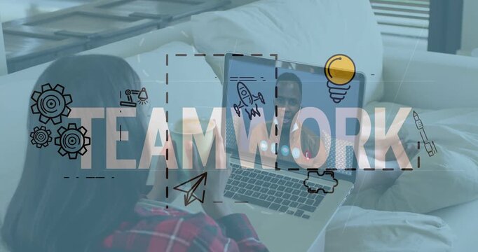 Holding mug, woman red-plaid shirt watching man on laptop on couch near blinds, with TEAMWORK icons