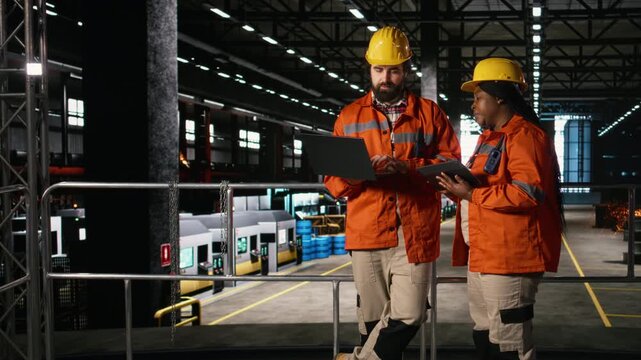 Diverse engineers, monitoring heavy equipment, large-scale plant, industrial teamwork, Machinery hall and metallic framework dominate the production line, engineering facility.