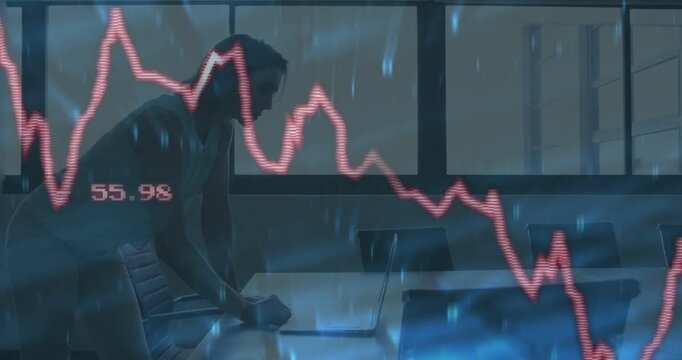 Woman responding to fluctuating red finance graph at conference table, typing and monitoring laptop
