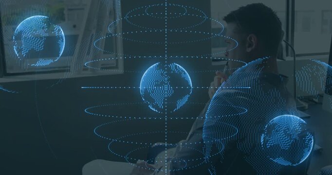Seated man watching hologram activating, rotating dotted globes crossing torso for tech demo