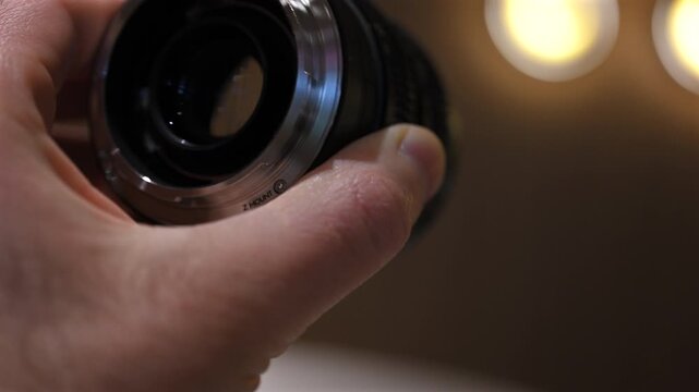 Close up of professional camera lens with aperture and focus rings being adjusted by hand