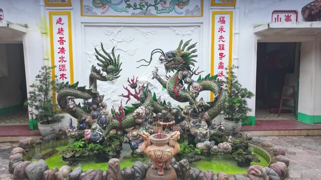 Dragons adorn the facade of a temple in Hoi An, Vietnam. The dragons are a symbol of power, strength, and good luck, and are often used in Vietnamese architecture.