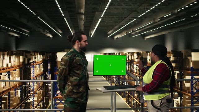 Isolated chroma key on monitor next to military personnel discussing supply shipment for defense operations, coordination and supervision. Diverse staff in a military base, storage hub.
