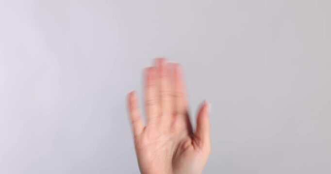 Welcome gesture. Woman waving on light grey background, closeup