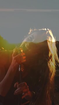 Vertical video: Lead singer holding mic, singing, motion shifting sun overlay, music drums playing