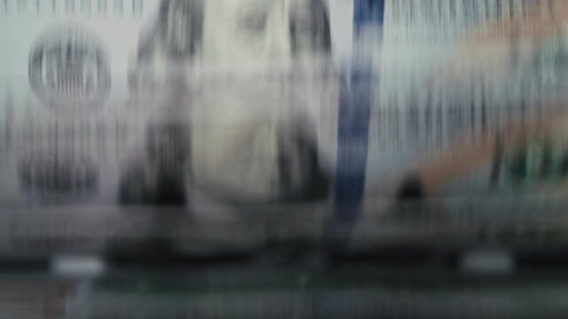 Close-up of one hundred dollar bills in money counter with digital display. Banking concept.
