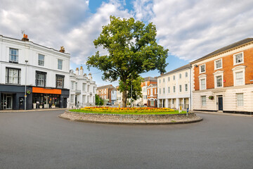 The picturesque roundabout at Broadway and Eastgate streets with a large tree and flower garden in the historic medieval old town of Winchester, England, UK. © Kirk Fisher