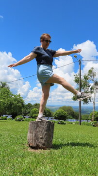 Woman balancing on the tree trunk