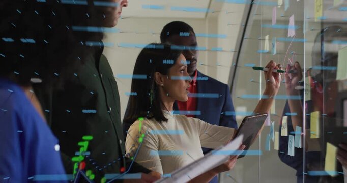 Diverse coworkers watching presenter annotating glass board with tablet, sticky notes and overlay