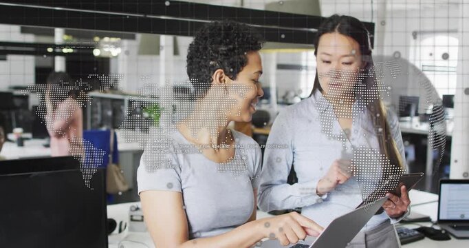 Left coworker angling laptop pointing right coworker tapping tablet reviewing work with dotted map