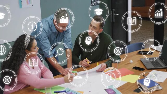 Team working on business planning, woman tapping phone and causing circular icons overlaying plan