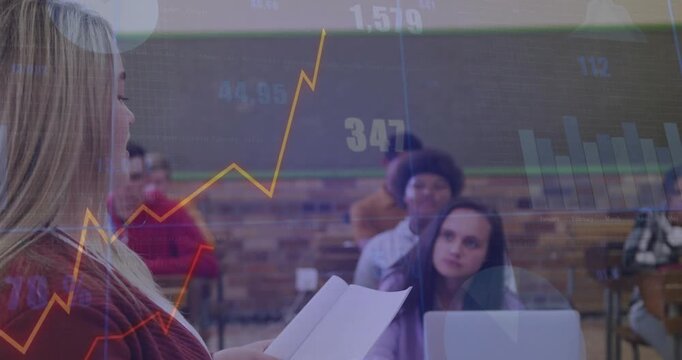 Presenter reading pages in class, causing animated finance charts and percent values showing trends