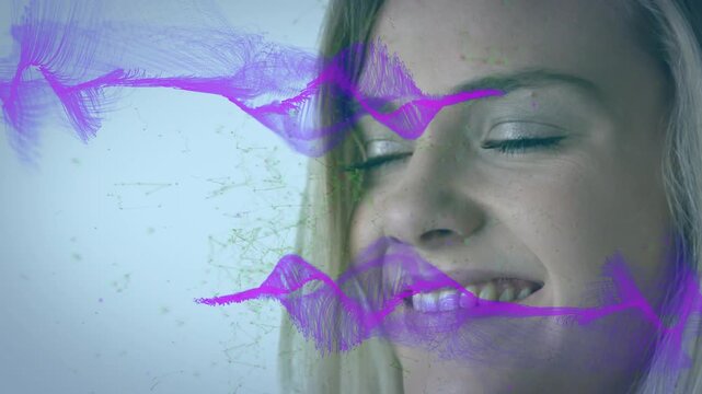 Woman smiling in studio while purple waveform appearing, sweeping across face, visualizing audio