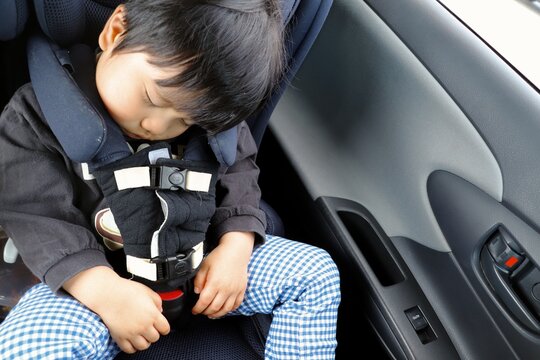 チャイルドシートで眠る日本人の幼児