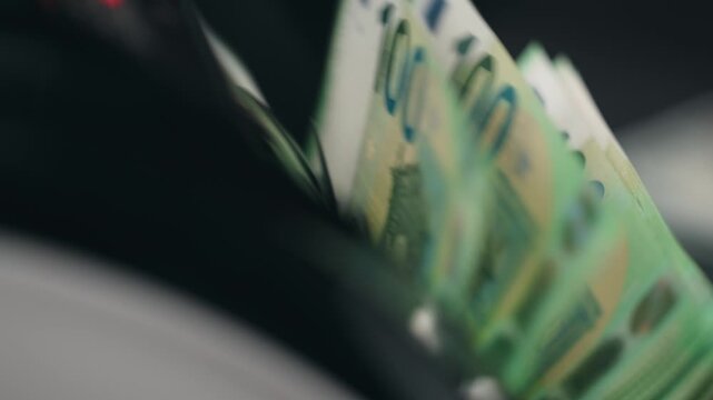 Close-up of one hundred euro bills running through electronic money counter. Finance concept.
