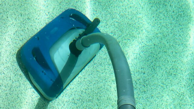 Blue Robotic Pool Cleaner Moving Across the Bottom of a Swimming Pool