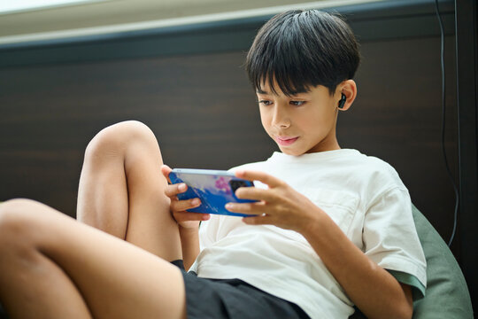 スマホゲームに集中する男の子のクローズアップ