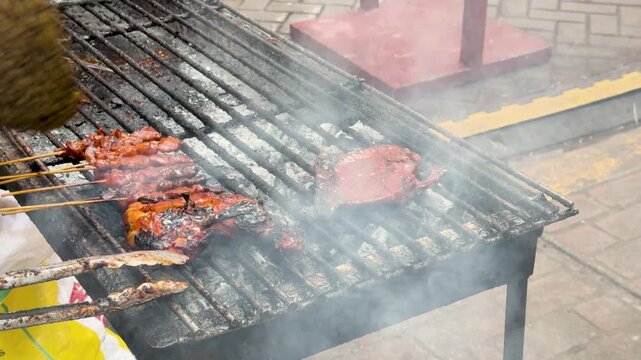 Street Food Vendor Grilling Marinated Meat Over Hot Charcoal in Manila