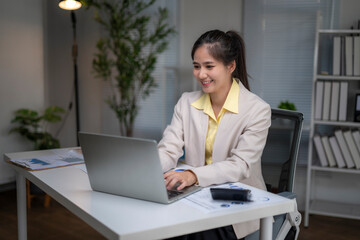 Fototapeta premium Asian business woman working on laptop in modern office
