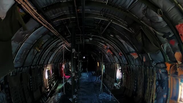 Dark and moody cinematic broll inside the empty cargo hold of a decaying vintage transport aircraft.