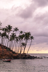 Tropical sunset at Coconut Tree Hill with a small boat anchored in the bay in Mirissa Sri Lanka © Anton Duris Photo