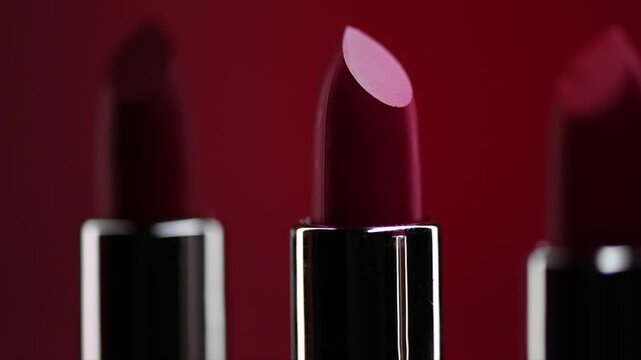 Red Lipstick set rotating. Matte red Colorful Lipsticks on red background. Red lipstick tints palette, Professional Makeup and beauty. Beautiful Make-up concept. Lipgloss. Lipsticks closeup 