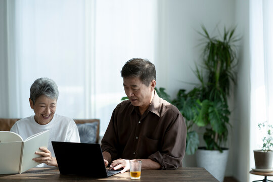 ノートパソコンを見る日本人シニア夫婦