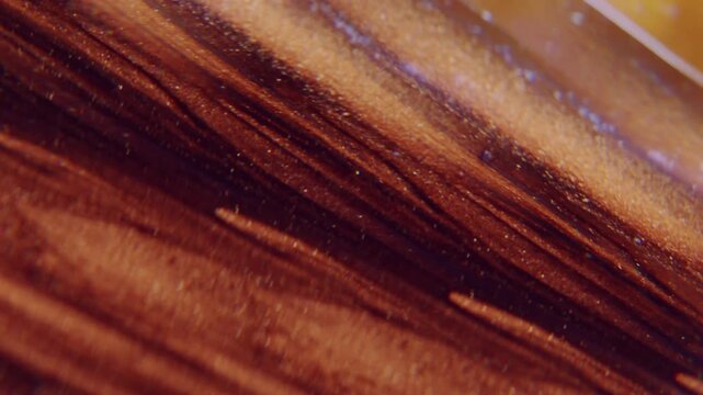 Ink whirl blur. Lens fluid. Glitter trickles stream kaleidoscopic rotation optical effect. Mix black orange brown color abstract background.