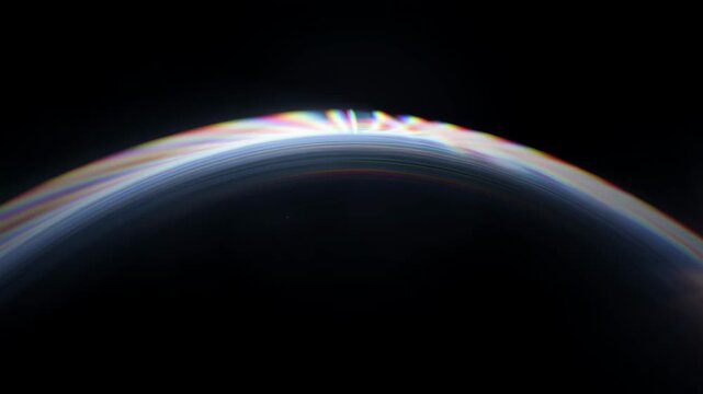 Abstract animation background refraction effect seamless render shape blue soft halo glowing over dark sunrise over curved horizon with light and prism refraction creating colorful soft fan shapes